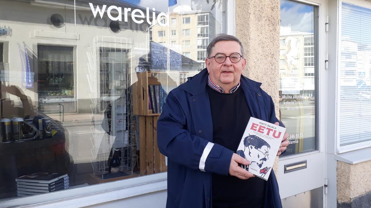 Pertti Rajala Eetu-kirja kädessään kustantamon kirjakaupan edessä.